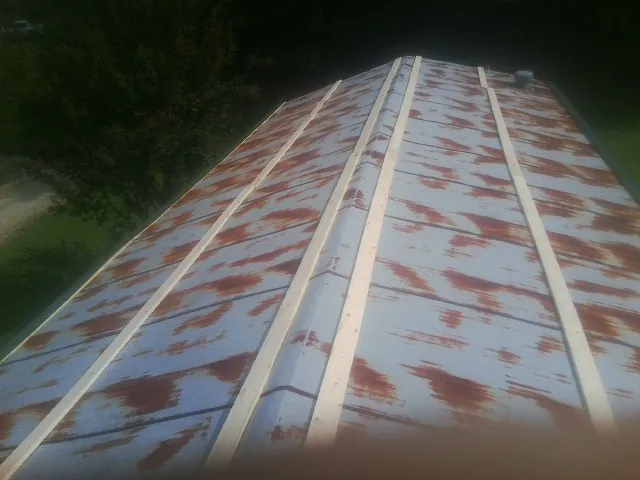 Rusted metal roof panels with new wood purlins before replacement — Storm Damage Roof Repair in Highlands by Roofing Brothers