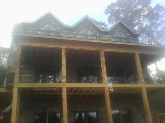 Dormers and porch framing on a large log home under construction — Roof Coating work by our crew in Highlands
